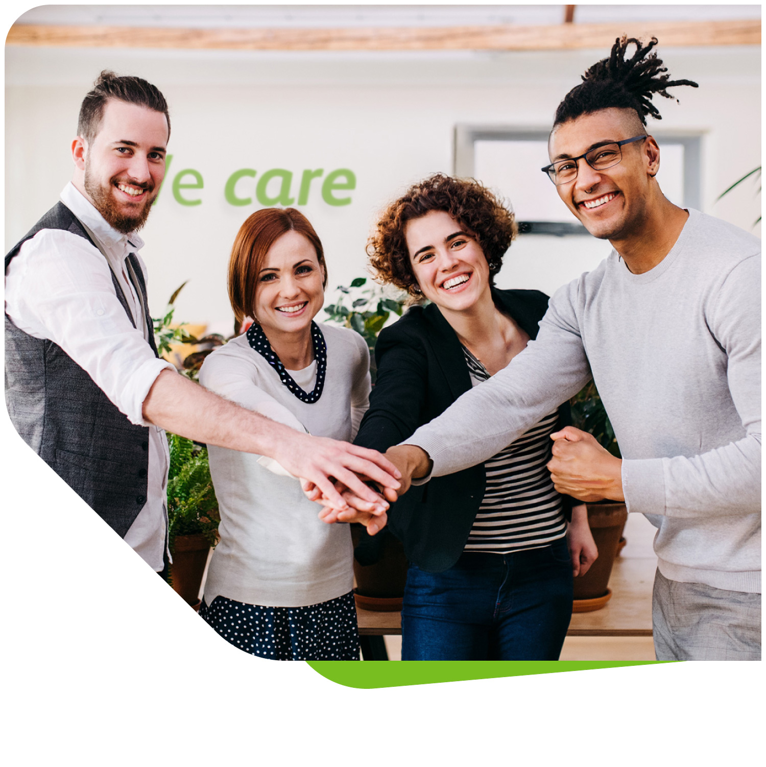 Vier lächelnde VIVISOL-Mitarbeiter stehen mit übereinandergelegten Händen im Team, was den starken Zusammenhalt und Teamgeist im Unternehmen symbolisiert.